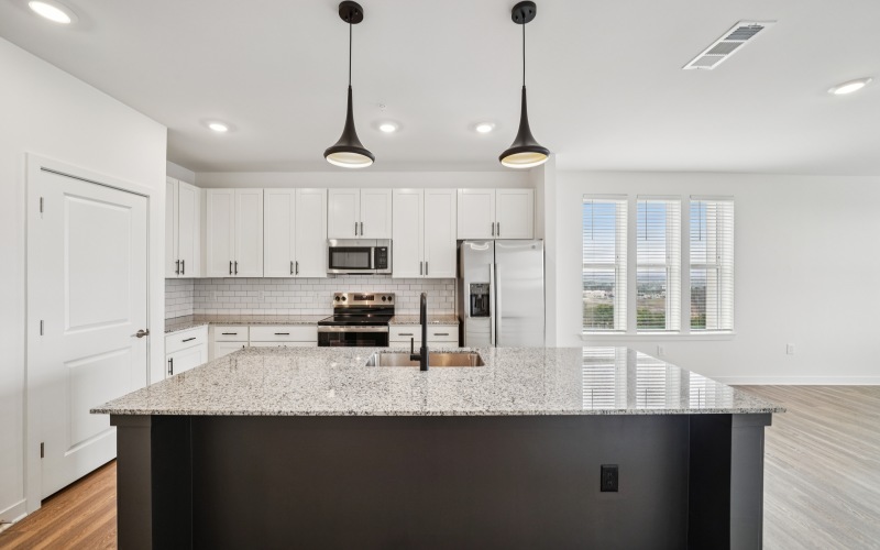 Kitchen with a  large island and granite countertops in the Cambria floor plan at Colina Hillside